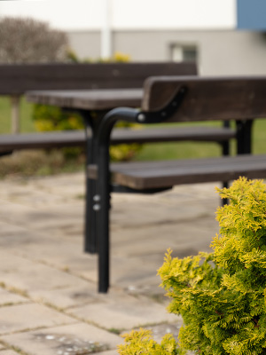 Close up shot of picnic table and park bench, you can see the detail on the material of the outdoor furniture.